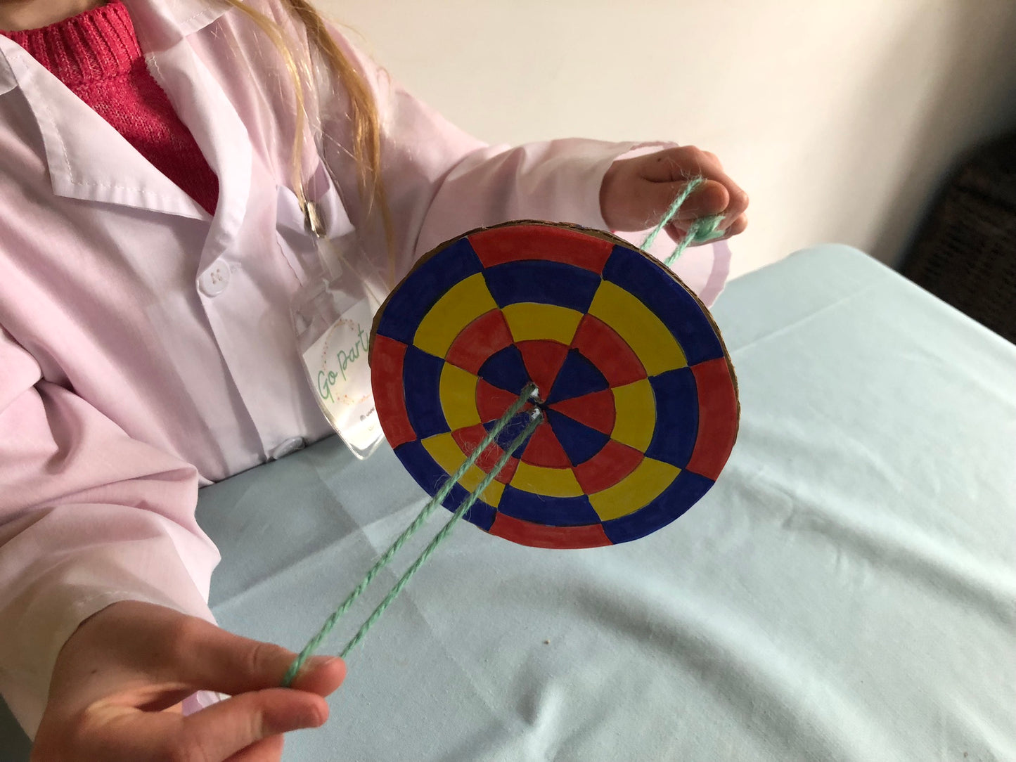 A child holding the colour changing spinner, coloured in using blue, red and yellow.