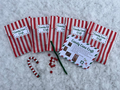 Five red striped bags labelled “Candy Cane Craft” sit in the snow. There is an instruction sheet with pictured, a green pipe cleaner, red and white beads, and a competed candy cane made out of the items.