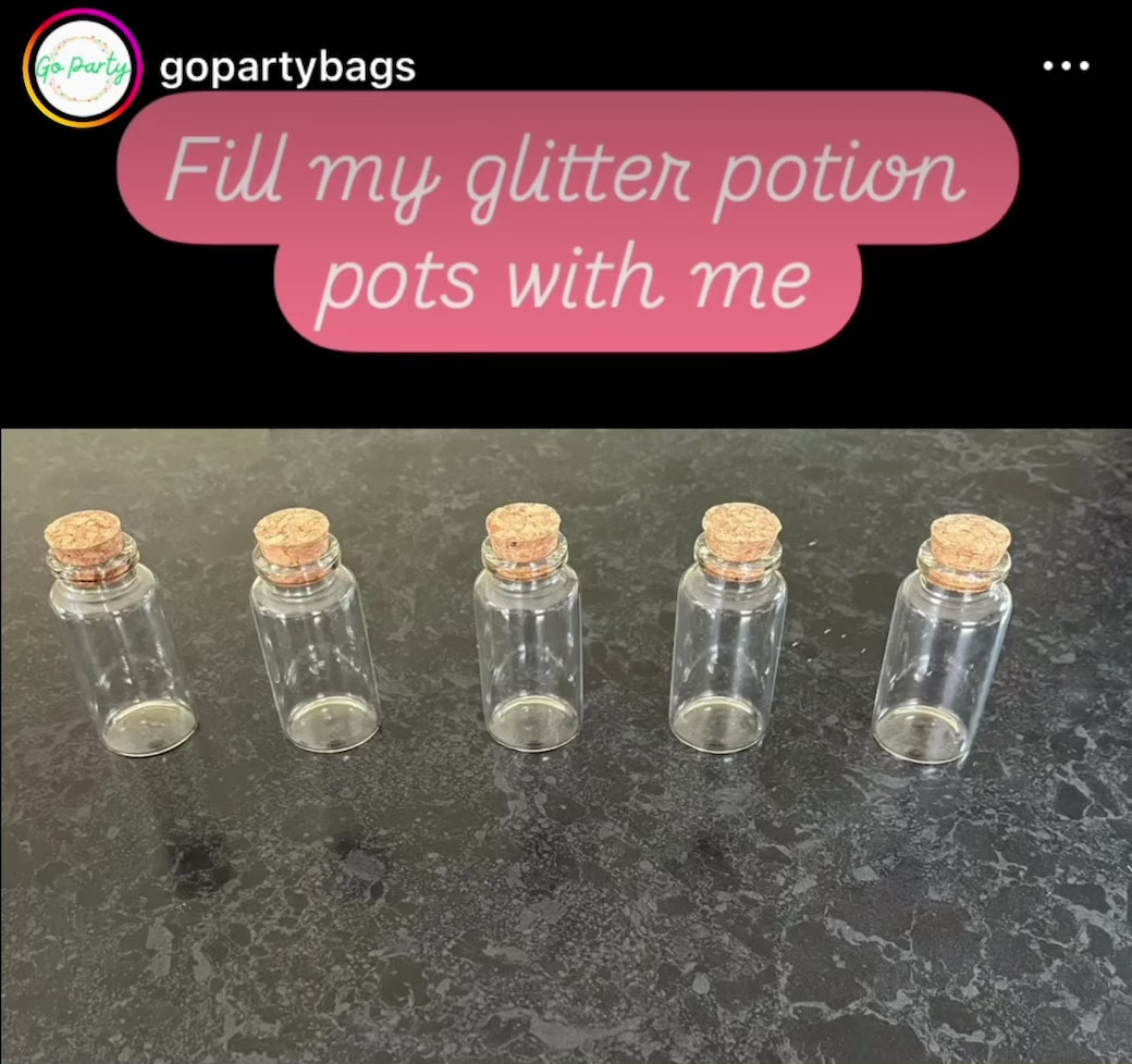 Load video: Video has the caption &quot;Fill my glitter potion pots with me&quot;. It shows a row of glass bottles, the corks all pop off, then a funnel is added to one, gold glitter goes into the bottle. The bottles fill one by one, with silver, red and green glitter.