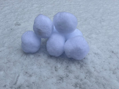 A stack of fluffy snowballs sit upon real snow.